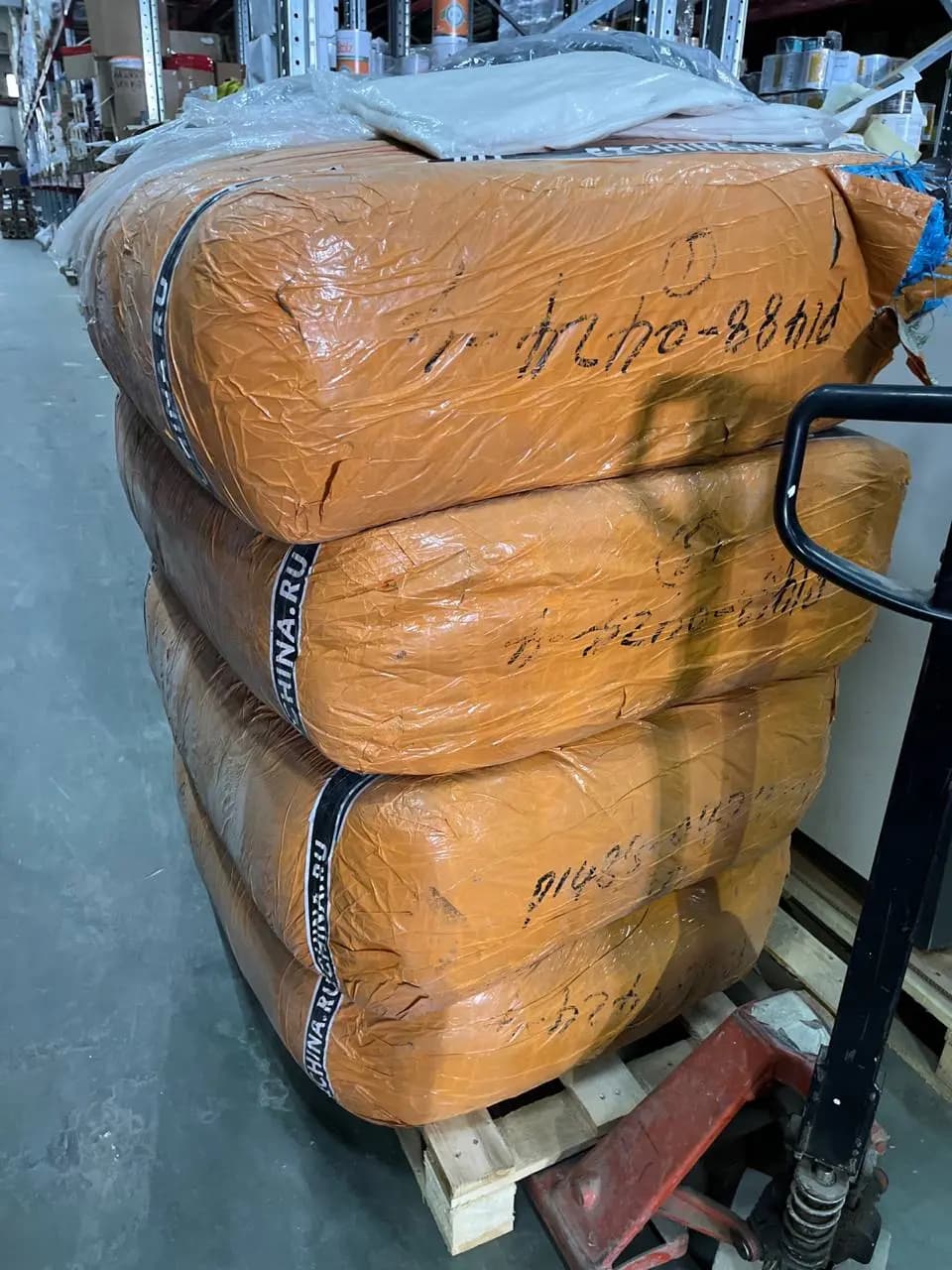 Паллета с мешками в оранжевой плёнке и ленте EZCHINA.RU на складе